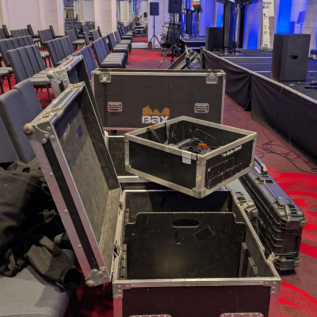Bax AV technical team unpacking equipment boxes during event bump-in, with cables, AV gear and tools being prepared for setup